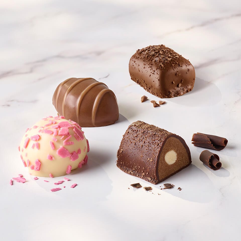 A group of assorted Classic Collection chocolates on a marble surface.