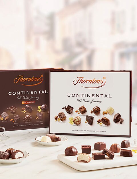 Thorntons Continental box on a table with chocolates on a plate with coffee.