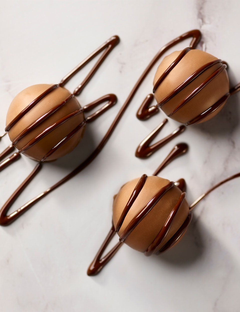 Thorntons milk chocolate drizzled on chocolates on a marble table