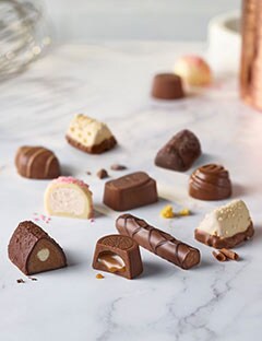 A group of assorted Classic Collection chocolates on a marble surface.