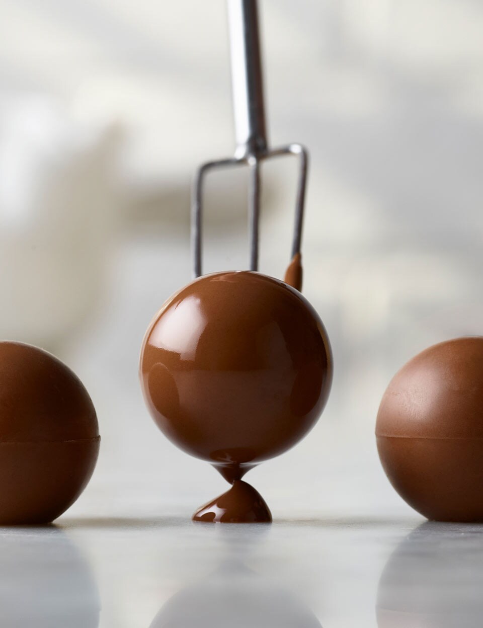 Three Thorntons Pearls chocolates in a line.