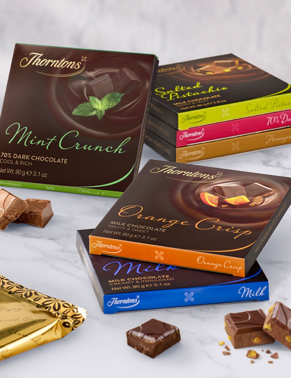 An assortment of Thorntons Chocolate blocks in stacks on a marble surface.