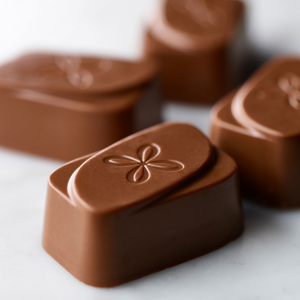 Group of milk chocolate Tempting Toffee chocolates on a marble surface.